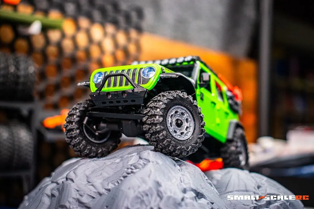 RC off-road vehicle climbing over rocks.