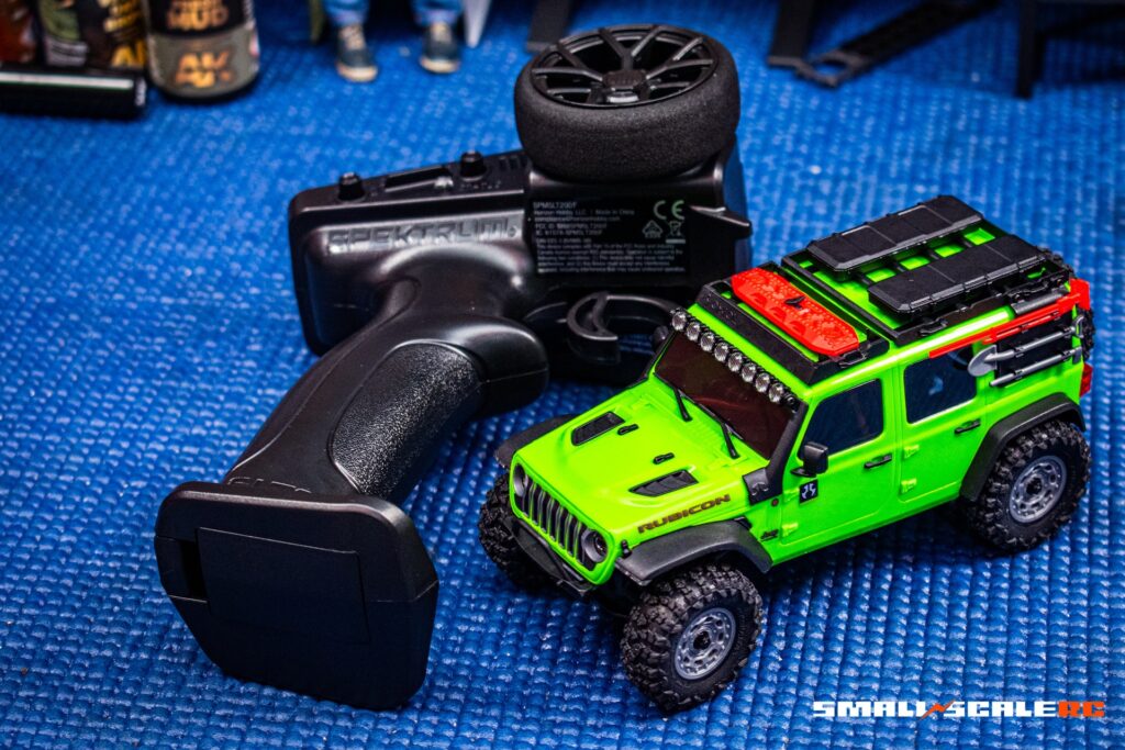Bright green small-scale RC off-road vehicle with rugged tires and detailed design.