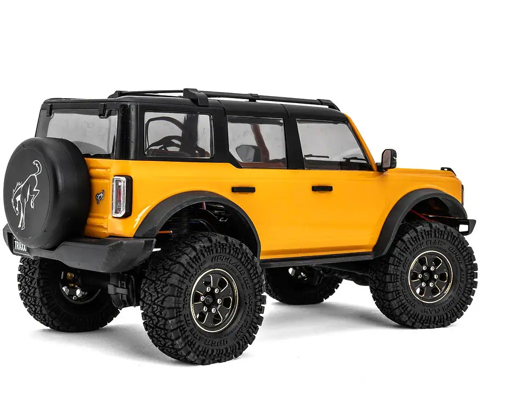A detailed yellow and black small-scale RC off-road vehicle with rugged tires and realistic design.